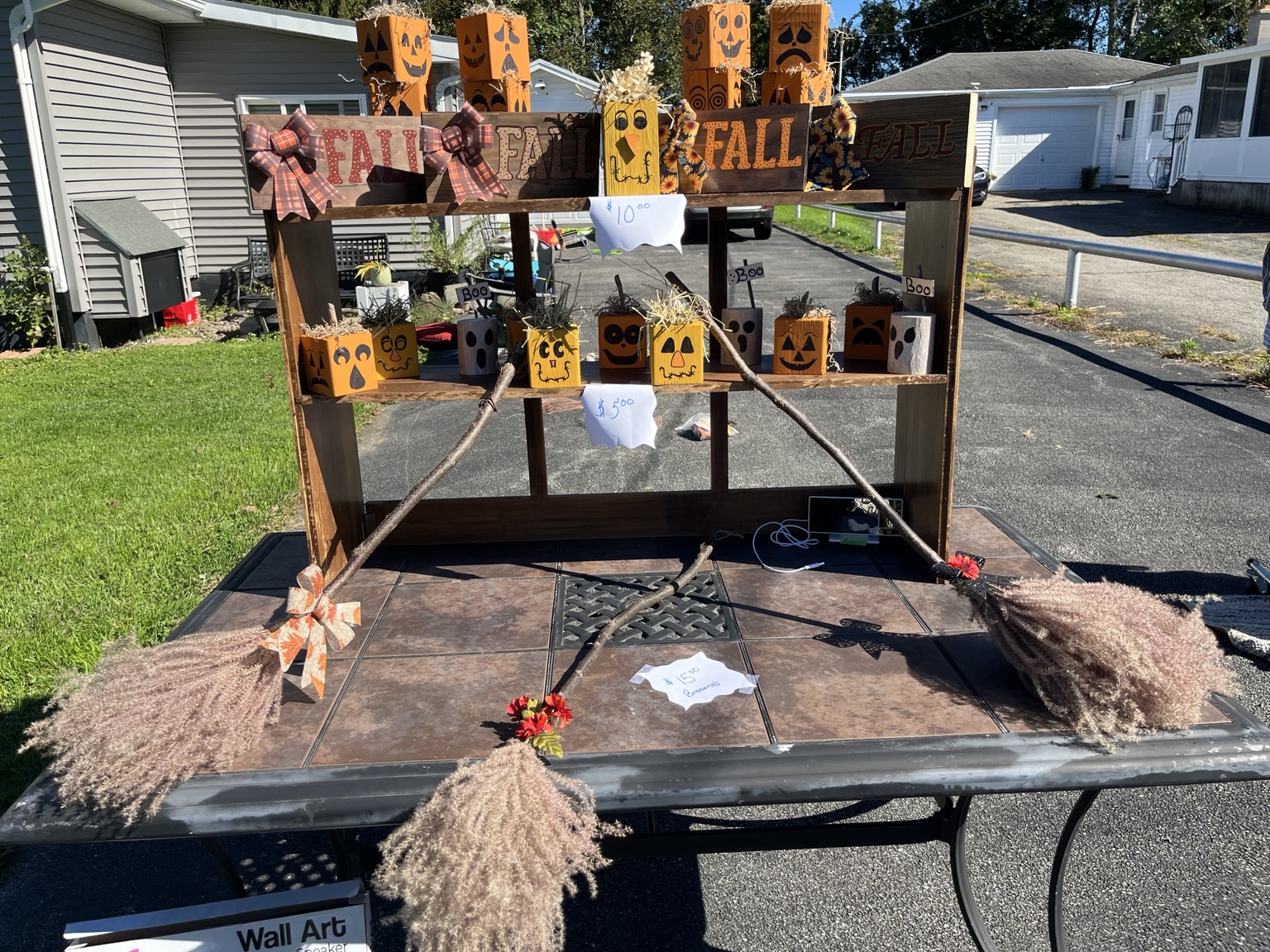 Tracy's fall craft display with hand-painted wooden pumpkin faces, fall signs, bows, and natural branches